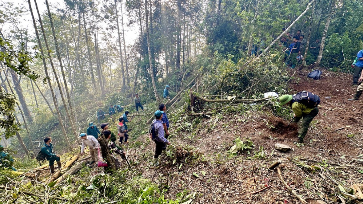 Lực lượng chức năng và người dân cắt đường băng cản lửa. (Ảnh: Báo Hà Giang)