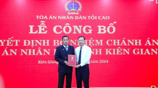 Ông Nguyễn Trí Tuệ - Phó Chánh án Thường trực TAND Tối cao (áo trắng) trao quyết định bổ nhiệm cho ông Võ Kế Nghiệp. Ảnh: Nhật Huy.