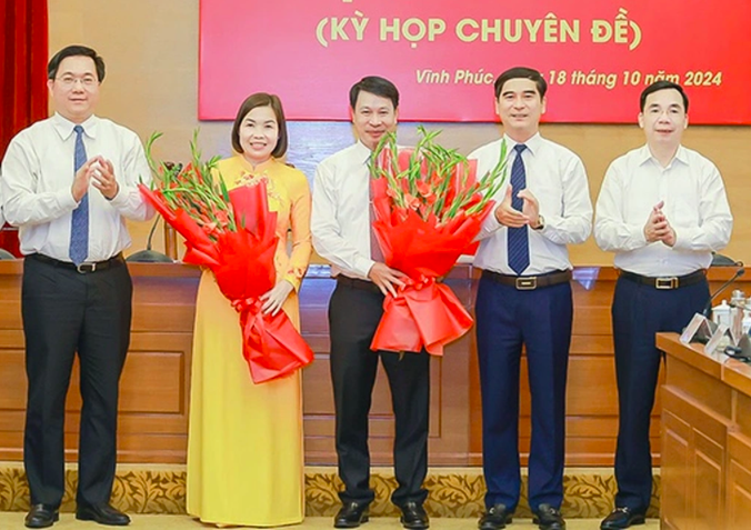 Lãnh đạo Tỉnh ủy, UBND tỉnh Vĩnh Phúc tặng hoa chúc mừng 2 tân Phó chủ tịch UBND tỉnh là ông Nguyễn Khắc Hiếu và bà Phùng Thị Kim Nga (Ảnh: Cổng TTĐT Vĩnh Phúc).