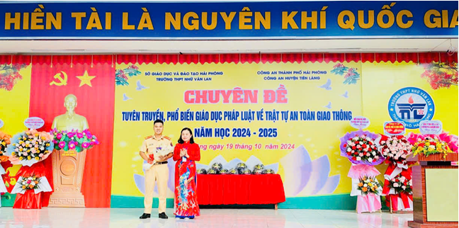 Nhà giáo Đỗ Thị Dung - Bí thư Đảng bộ, Hiệu trưởng trường THPT Nhữ Văn Lan tặng hoa cho báo cáo viên. Ảnh Đằng Giang