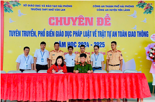 Đại diện CA huyện, BGH nhà trường và đại diện phụ huynh học sinh ký kết phối hợp về tuyên truyền giáo dục ATGT. Ảnh Đằng Giang