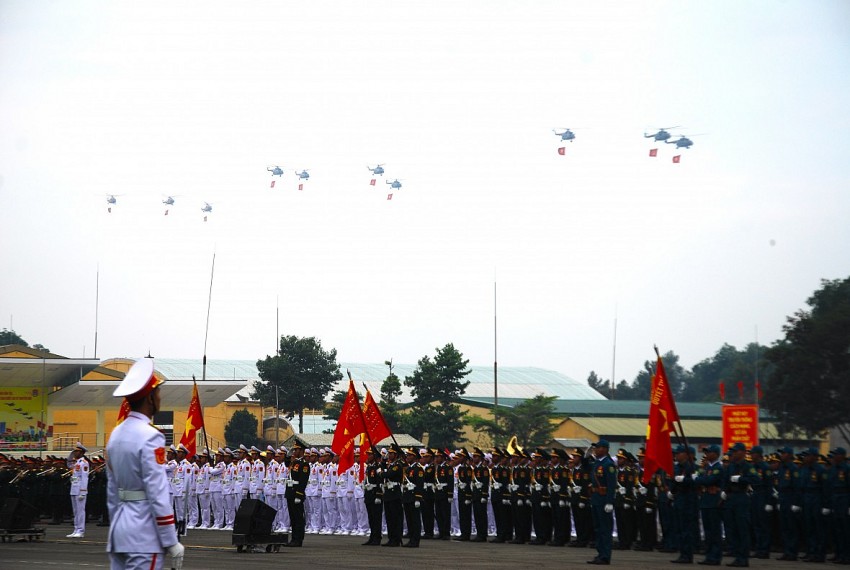 Không quân Việt Nam mang theo cờ đảng, cờ tổ quốc diễu hành qua lễ đài.