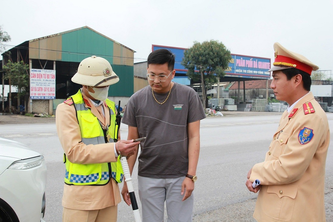 Lực lượng CSGT kết hợp tuyên truyền Luật Giao thông đường bộ cho lái xe. (Ảnh: Công an Nghệ An)