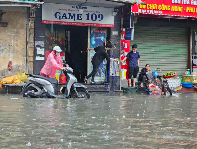 Đường Đỗ Đức Dục quận Nam Từ Liêm bị ngập sâu khiến nhiều xe bị chết máy.