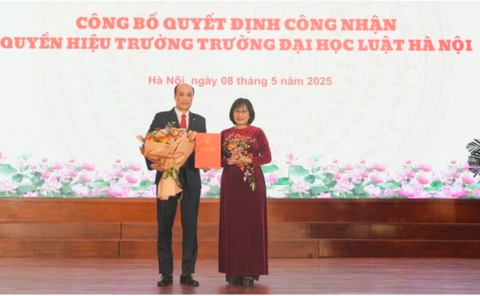 Thứ trưởng Bộ Tư pháp Đặng Hoàng Oanh trao quyết định cho ông Tô Văn Hòa, quyền Hiệu trưởng Trường Đại học Luật Hà Nội (Ảnh: Phương Mai).