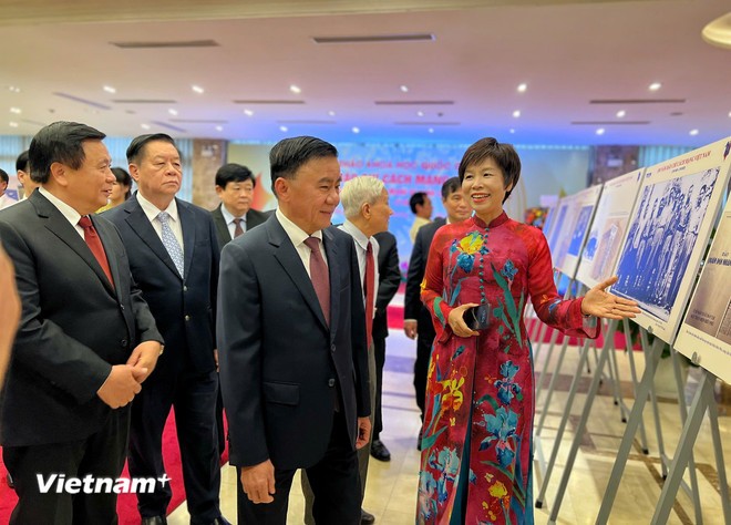 Tổng Giám đốc Thông tấn xã Việt Nam giới thiệu những hình ảnh quý tại Trưng bày ảnh chuyên đề với các lãnh đạo Đảng, Nhà nước, đại diện lãnh đạo các ban, bộ, ngành, cơ quan Trung ương tham dự Hội thảo. (Ảnh: Mai Mai/Vietnam+)