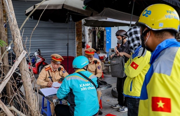 Đội CSGT số 7 (Phòng CSGT Hà Nội) xử phạt nghiêm hàng loạt xe ôm công nghệ vi phạm luật giao thông. (Ảnh: TTXVN)