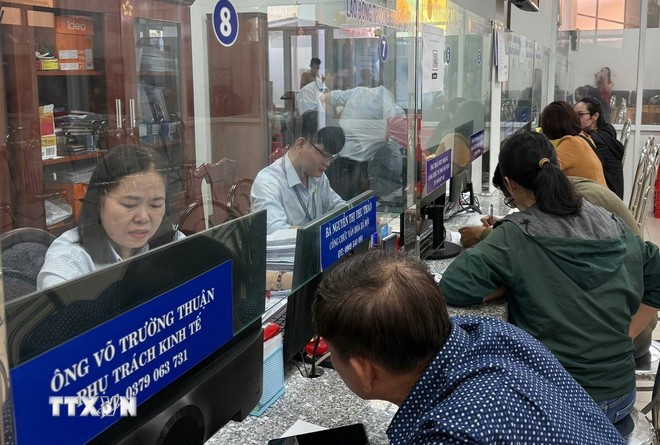 Cán bộ công chức giải thích, tư vấn, hướng dẫn để người dân nắm rõ các thủ tục hành chính. (Ảnh: Hữu Duyên/TTXVN)