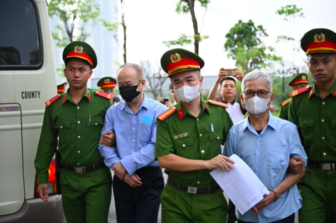 Cảnh sát dẫn giải các bị cáo vào phòng xét xử