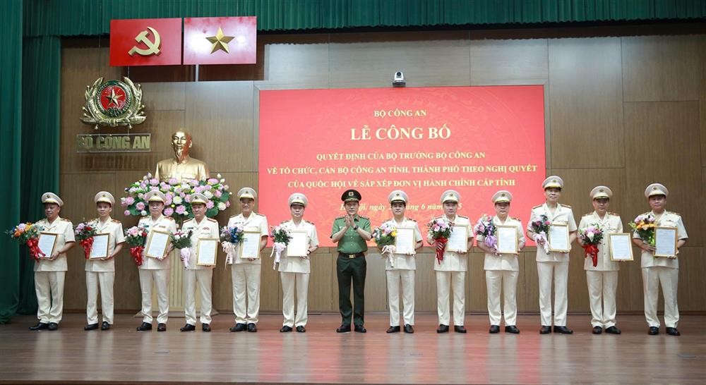 Bộ trưởng Lương Tam Quang trao Quyết định và tặng hoa chúc mừng 23 đồng chí Giám đốc Công an địa phương sau sáp nhập. Công an