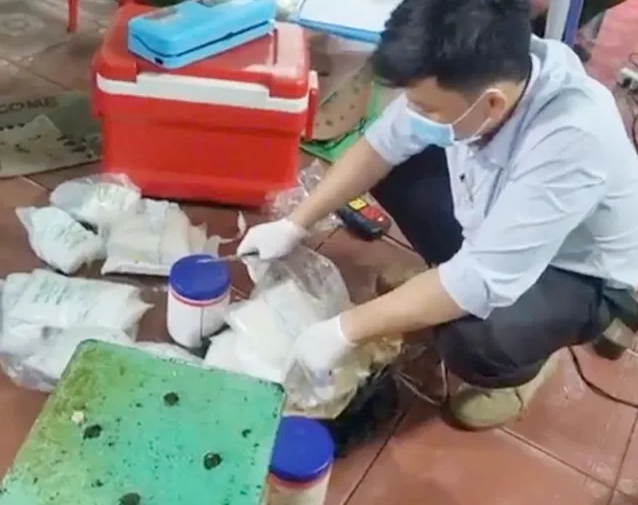 Lực lượng chức năng thu giữ hóa chất tại một cơ sở chế biến hoa chuối. Ảnh: C.A.