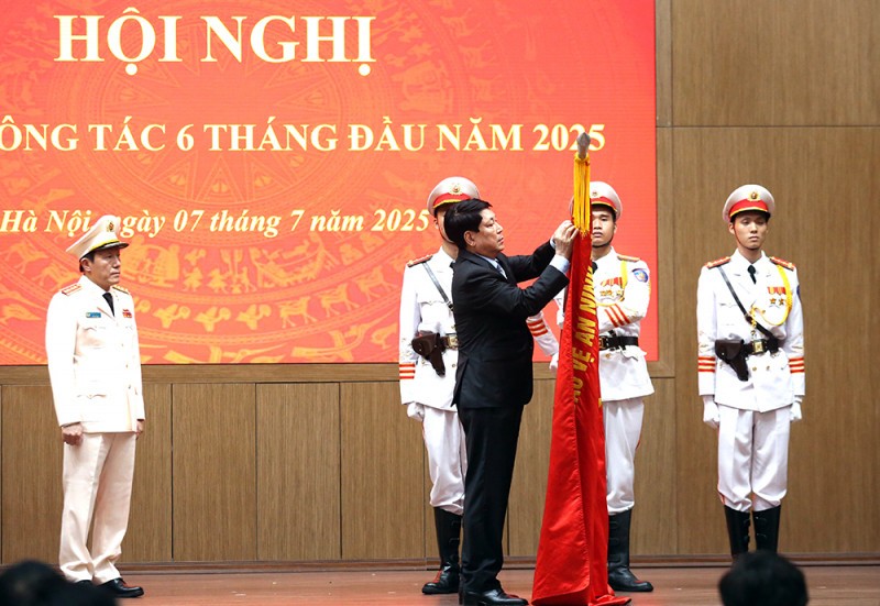 Chủ tịch nước Lương Cường gắn Huân chương Lao động hạng Ba lên Cờ truyền thống của Bộ Công an. Ảnh: CAND