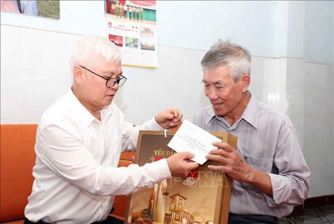 Ông Nguyễn Văn Lợi (trái), Ủy viên Trung ương Đảng, Trưởng Đoàn ĐBQH Thành phố Hồ Chí Minh thăm, tặng quà gia đình người có công với Cách mạng tại phường Đông Hưng Thuận. Ảnh: TTXVN