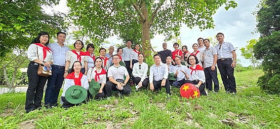 Những người làm Báo Pháp luật Việt Nam bên gốc cây bồ đề tại Ngã ba Đồng Lộc.