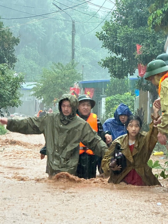 Lực lượng chức năng đưa người dân ra khỏi vùng nguy hiểm tại xã Na Son.