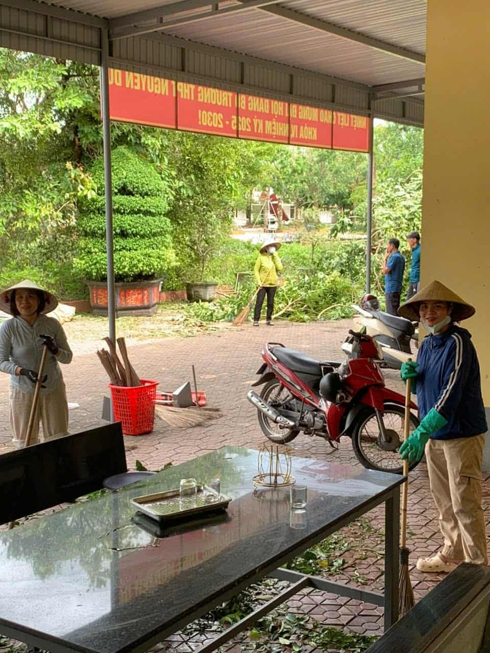 Cán bộ, giáo viên trường THPT Nguyễn Du khắc phục hậu quả do mưa bão gây ra tại khu vực trường.