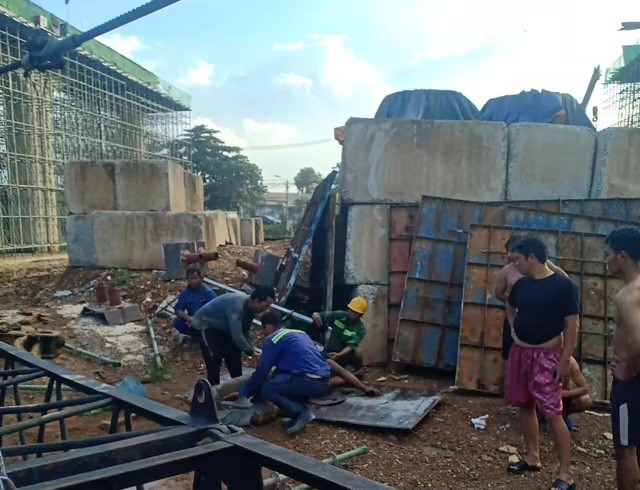 Các công nhân sơ cứu cho 2 nạn nhân bị cần cẩu sập đè. Các công nhân sơ cứu cho 2 nạn nhân bị cần cẩu sập đè.