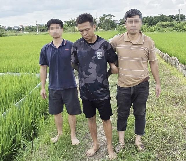 Đối tượng Ngô Quang Vỹ bị bắt giữ khi tháo chạy ra cánh đồng gần nhà.