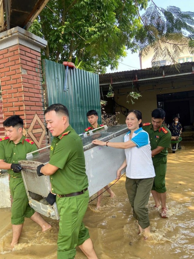 Các chiến sĩ giúp người dân khiêng các đồ điện tử để đảm bảo an toàn khi sử dụng.