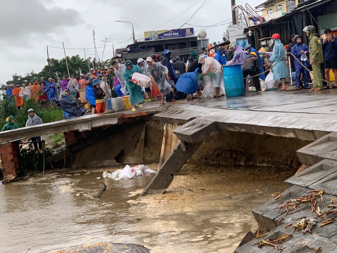 Lực lượng chức năng cùng người dân gia cố các điểm sạt lở bằng đá, bao cát.