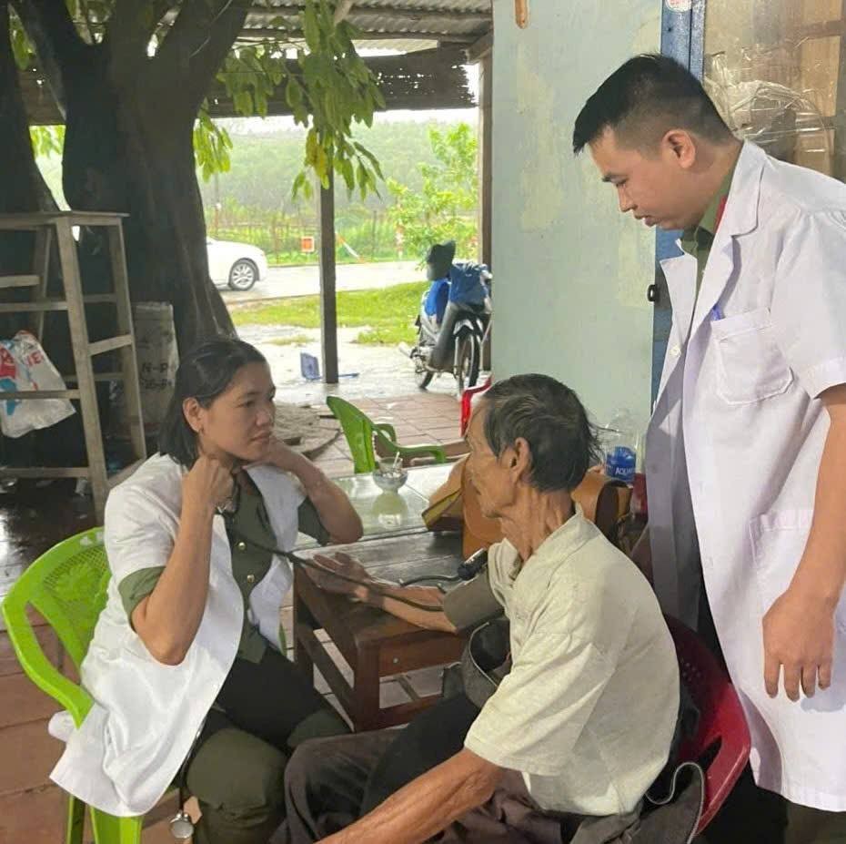 Chiến sĩ Bệnh xá CATP Đà Nẵng hộ trợ bà con vùng lũ - Ảnh Công an Đà Nẵng.