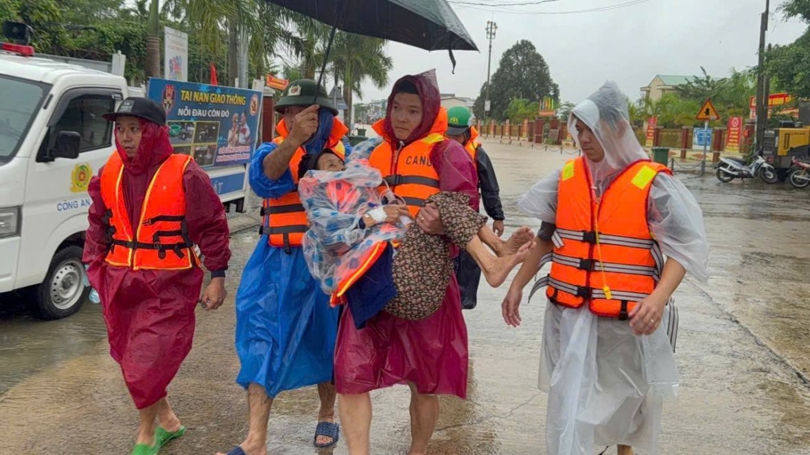 Người già được hỗ trợ di chuyển ra khỏi vùng lũ - Ảnh Công an Đà Nẵng.