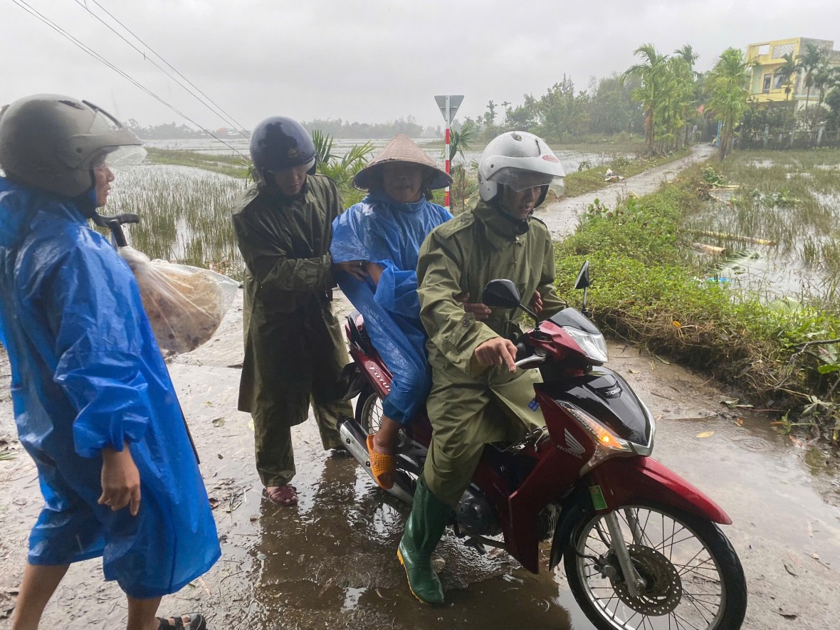 Lực lượng chức năng xã Tam Xuân hỗ trợ sơ tán người già đi tránh bão số 13