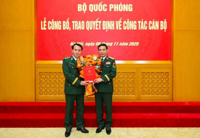 Đại tướng Phan Văn Giang trao quyết định và tặng hoa chúc mừng Trung tướng Vũ Trung Kiên (Ảnh: Ngọc Minh).