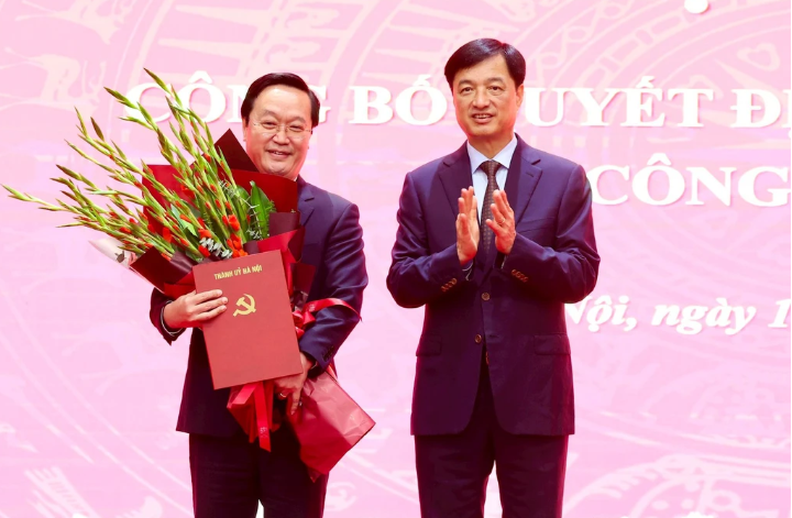 Bí thư Thành ủy Hà Nội Nguyễn Duy Ngọc (bên phải) tặng hoa chúc mừng ông Nguyễn Đức Trung. 