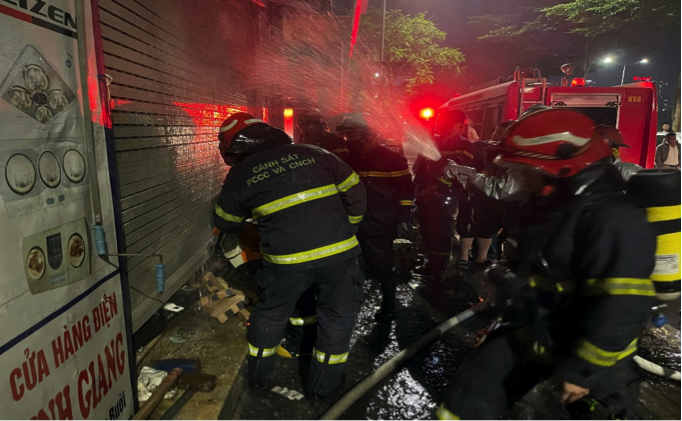 Ảnhlực lượng Cảnh sát PCCC&CNCH phá cửa cuốn tại tầng 1 để chữa cháy và CNCH.