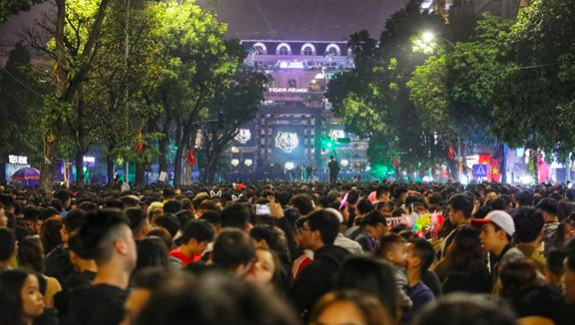 Hàng nghìn người đổ về hồ Hoàn Kiếm để cùng nhau tạm biệt năm cũ và đón chào năm mới.