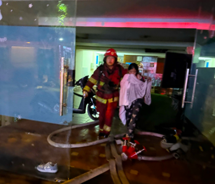 Lực lượng cứu nạn hỗ trợ đưa người mắc kẹt trogn đám cháy đến nơi an toàn.