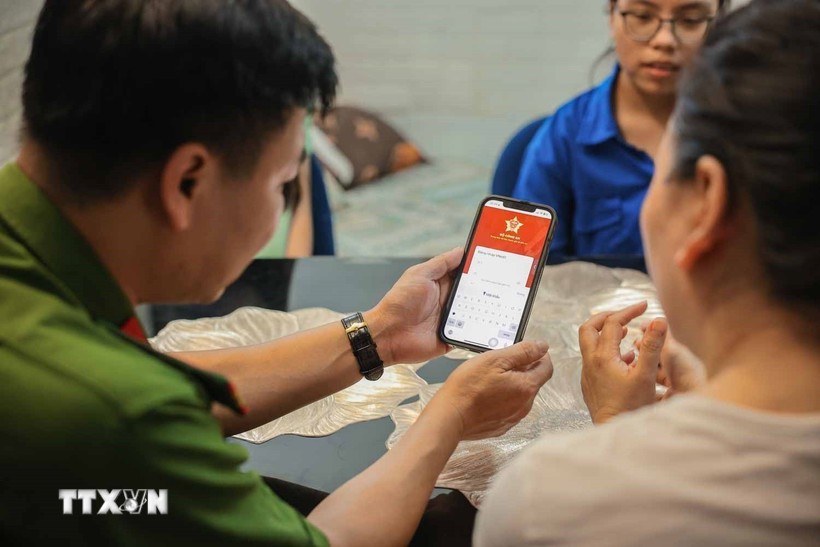 Tổ chuyển đổi số cộng đồng hướng dẫn người dân sử dụng ứng dụng VNeID. Ảnh: TTXVN Tổ chuyển đổi số cộng đồng hướng dẫn người dân sử dụng ứng dụng VNeID. Ảnh: TTXVN