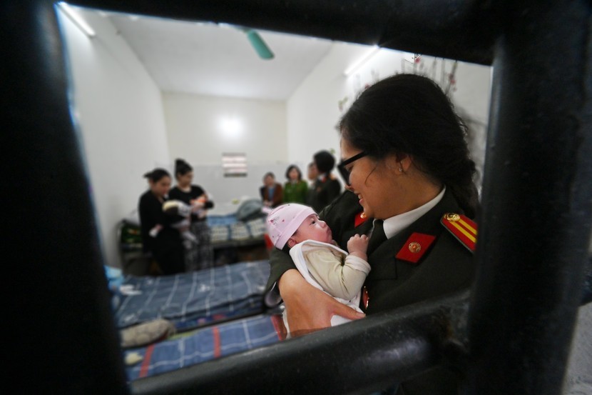 Hình ảnh xúc động qua khung cửa buồng giam: Nữ cán bộ Công an Thủ đô bế trên tay cháu bé sơ sinh. Trong buồng này còn có một cháu bé mới sinh được 4 ngày tuổi...