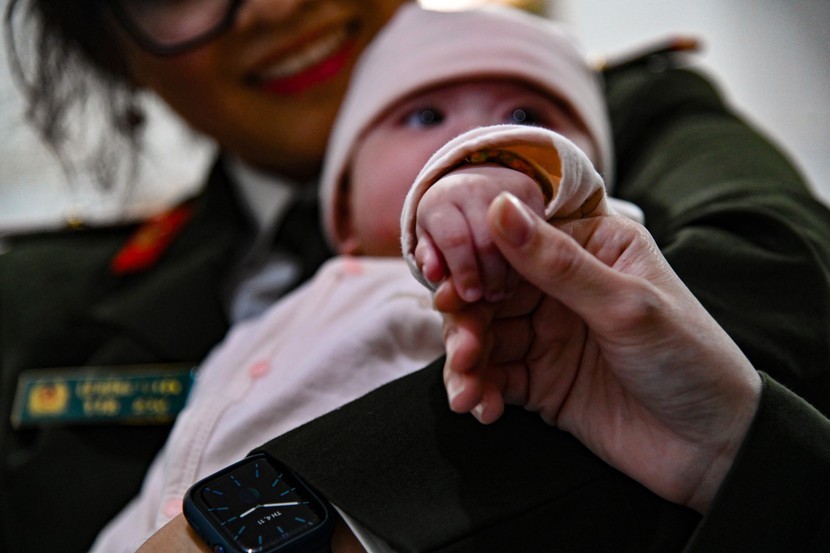 Bàn tay bé xíu của thiên thần nhỏ nắm chặt lấy ngón tay của nữ chiến sĩ Công an. Một sự tin cậy tuyệt đối và bình yên đến lạ thường.