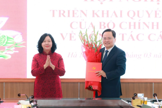 Chủ tịch Ủy ban Trung ương Mặt trận tổ quốc Việt Nam Bùi Thị Minh Hoài trao quyết định và tặng hoa chúc mừng ông Nguyễn Anh Tuấn 