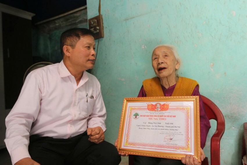 Ông Phùng Khắc Đệ, Bí thư Chi bộ thôn, Tổ trưởng tổ bầu cử thôn Thạch, xã Tây Phương bên cụ bà Đặng Thị Chín.