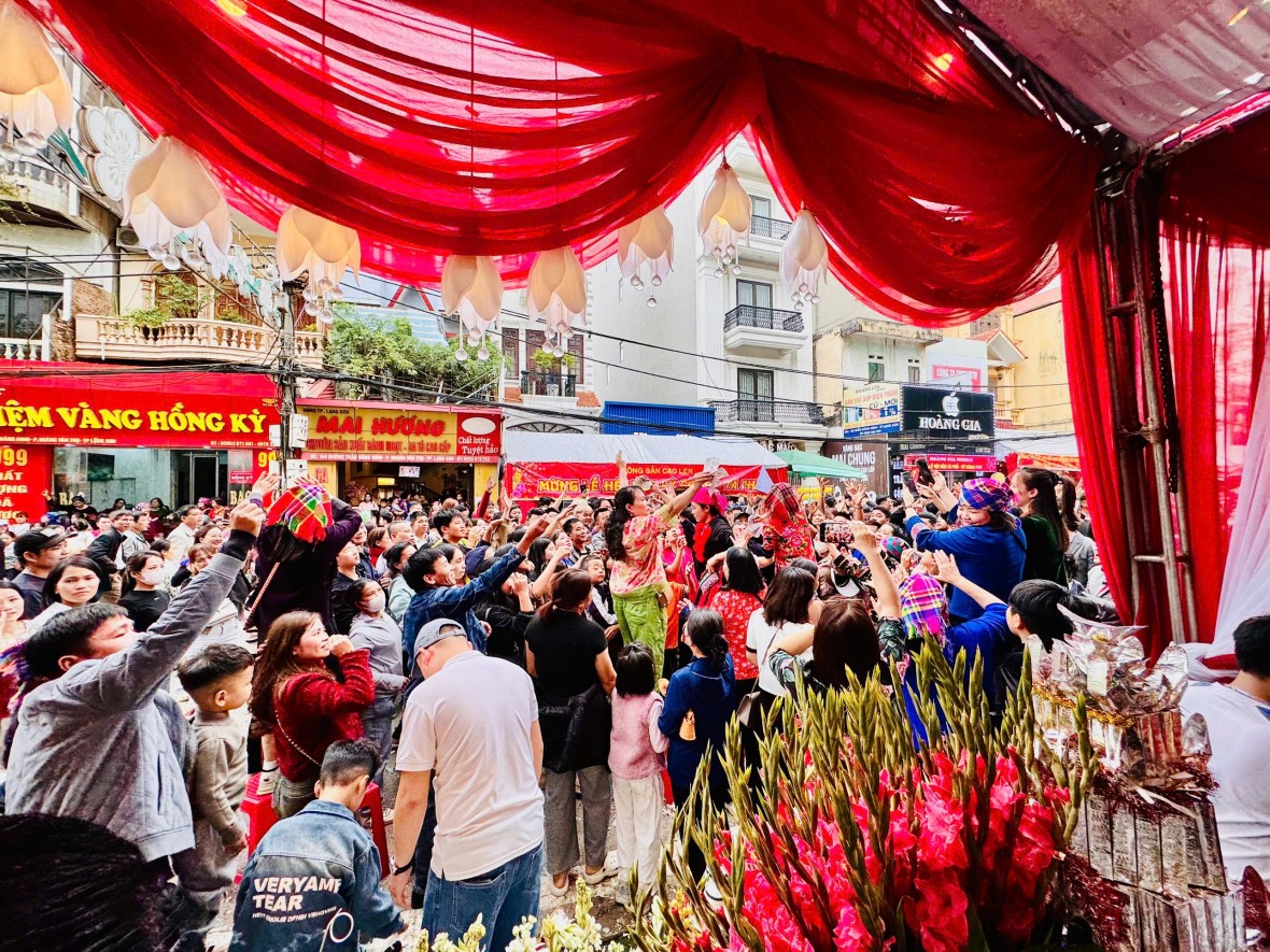 Khi đoàn rước đi qua, các cửa hàng trên tuyến phố trung tâm bắt đầu tung tiền “tán lộc”, tạo nên khung cảnh sôi động đặc trưng của phố lễ hội Kỳ Cùng – Tả Phủ.