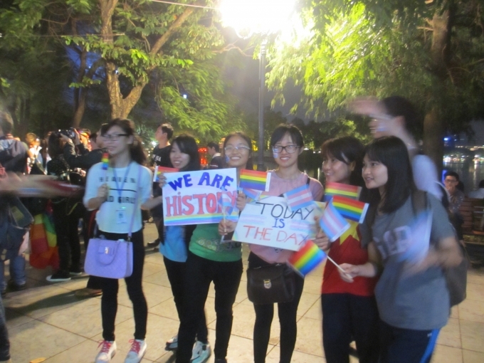 C&aacute;c bạn trẻ đeo băng r&ocirc;n khẩu hiệu ch&uacute;c mừng người chuyển giới, h&ocirc; vang khẩu hiệu