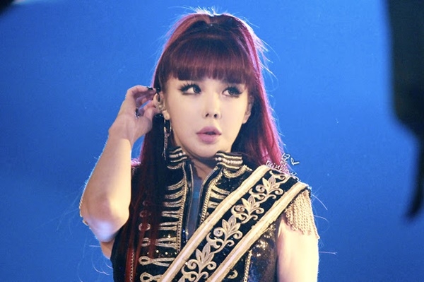 Park Bom (2NE1) g&acirc;y sốc với khu&ocirc;n mặt căng phồng, mũi cao nhọn kh&aacute;c lạ, tr&ocirc;ng như b&uacute;p b&ecirc; nhựa. Diện mạo nữ ca sĩ ng&agrave;y c&agrave;ng kỳ qu&aacute;i khiến c&aacute;c fan lo lắng v&agrave; đề nghị c&ocirc; ngừng lạm dụng phẫu thuật thẩm mỹ.