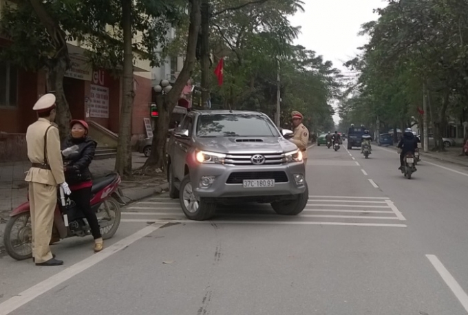 Lực lượng chức năng nhắc nhở để người d&acirc;n hiểu việc th&iacute; điểm đường một chiều tr&ecirc;n đường Đinh C&ocirc;ng Tr&aacute;ng (Ảnh: Duy Ngợi).