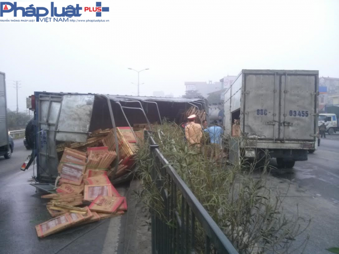 H&agrave;ng h&oacute;a trong xe tải đổ tr&agrave;n lan ra đường.