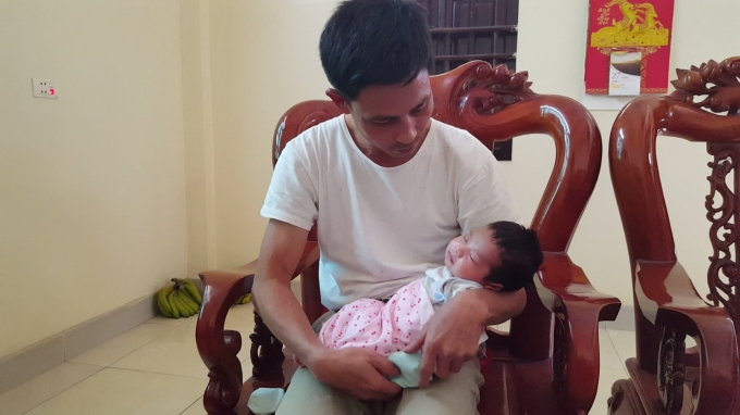 Anh Đ&agrave;m Văn Hưởng (chồng sản phụ Nguyễn Thị K.) phải ở nh&agrave; chăm con sau khi vợ mất. Ảnh: Huy Trung