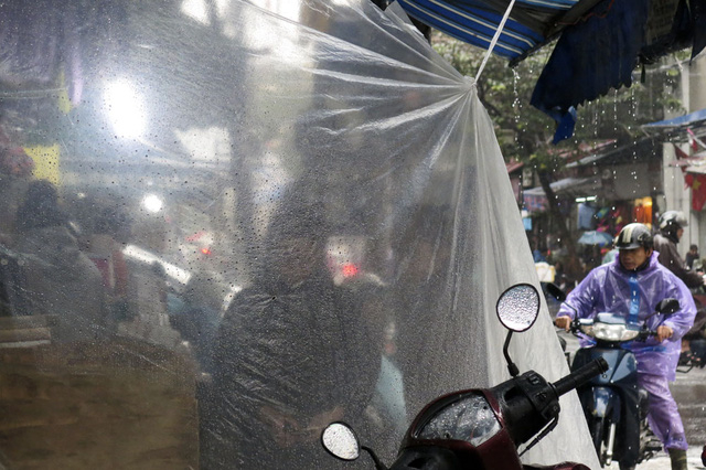 Nhiều cửa h&agrave;ng mặt phố bu&ocirc;n b&aacute;n đều phải che chắn th&ecirc;m tr&aacute;nh gi&oacute; tạt nước l&agrave;m ướt h&agrave;ng h&oacute;a.