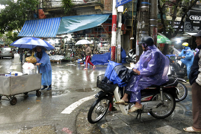 Người l&aacute;i xe &ocirc;m đội mưa chờ kh&aacute;ch, c&ocirc;ng việc kiếm sống h&agrave;ng ng&agrave;y trở n&ecirc;n vất vả hơn nhiều.