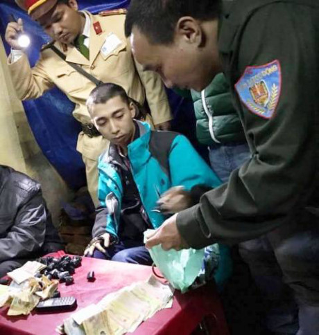 Một trong những đối tượng (&aacute;o xanh) bị lực lượng chức năng bắt giữ.