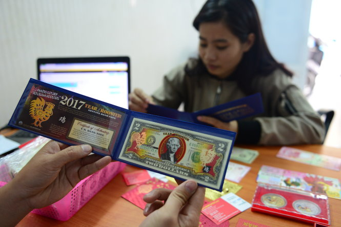 Bạn Quỳnh Nga (Q.G&ograve; Vấp, TP.HCM) mua tiền l&igrave; x&igrave; tết 2017 mệnh gi&aacute; 2 USD c&oacute; h&igrave;nh con g&agrave; qua trang facebook.com/shoplixitet tr&ecirc;n đường Nguyễn Kiệm, Q.Ph&uacute; Nhuận - Ảnh: Quang Định