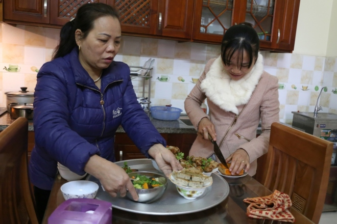 B&agrave; Tuyết c&ugrave;ng con g&aacute;i sắp xếp m&acirc;m cơm, canh để c&uacute;ng.