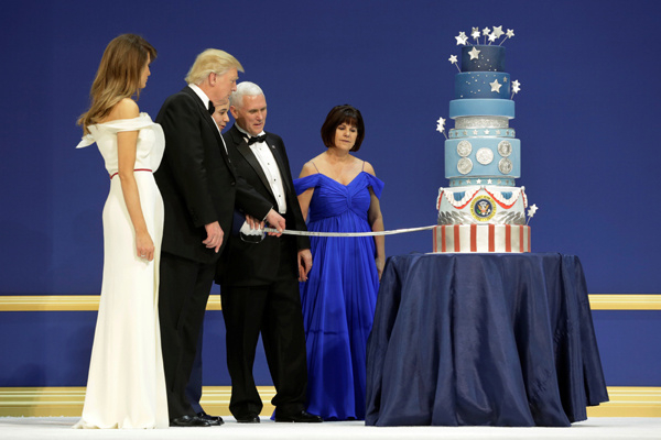 Vợ chồng t&acirc;n Tổng thống v&agrave; ph&oacute; Tổng thống d&ugrave;ng một c&acirc;y kiếm d&agrave;i l&agrave;m nghi thức cắt b&aacute;nh kem của qu&acirc;n đội. Sau đ&oacute;, họ vẫy tay ch&agrave;o v&agrave; rời khỏi buổi tiệc. (Ảnh: AP)