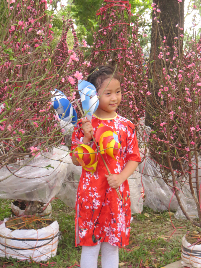 C&aacute;c em nhỏ được bố mẹ trưng diện quần &aacute;o tham quan chợ hoa.